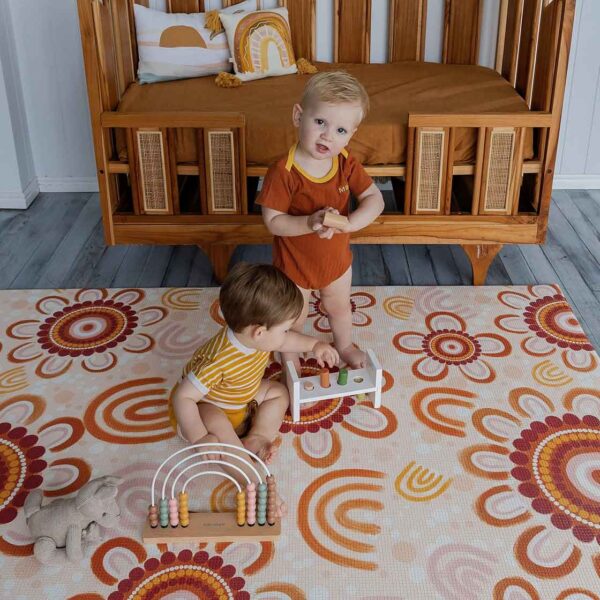 baby plays on indegenous play mat by Rockabye River and Bunya Designs.