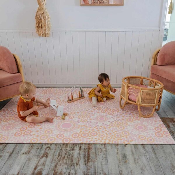 Two babies are playing on the playmat